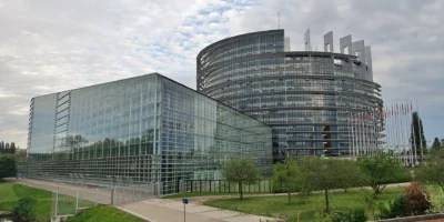 Edifício do Parlamento Europeu em Estrasburgo com fachadas de vidro e bandeiras