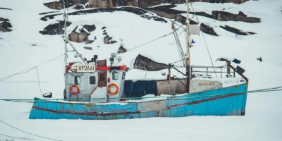 Barco de pesca numa paisagem polar coberta de neve